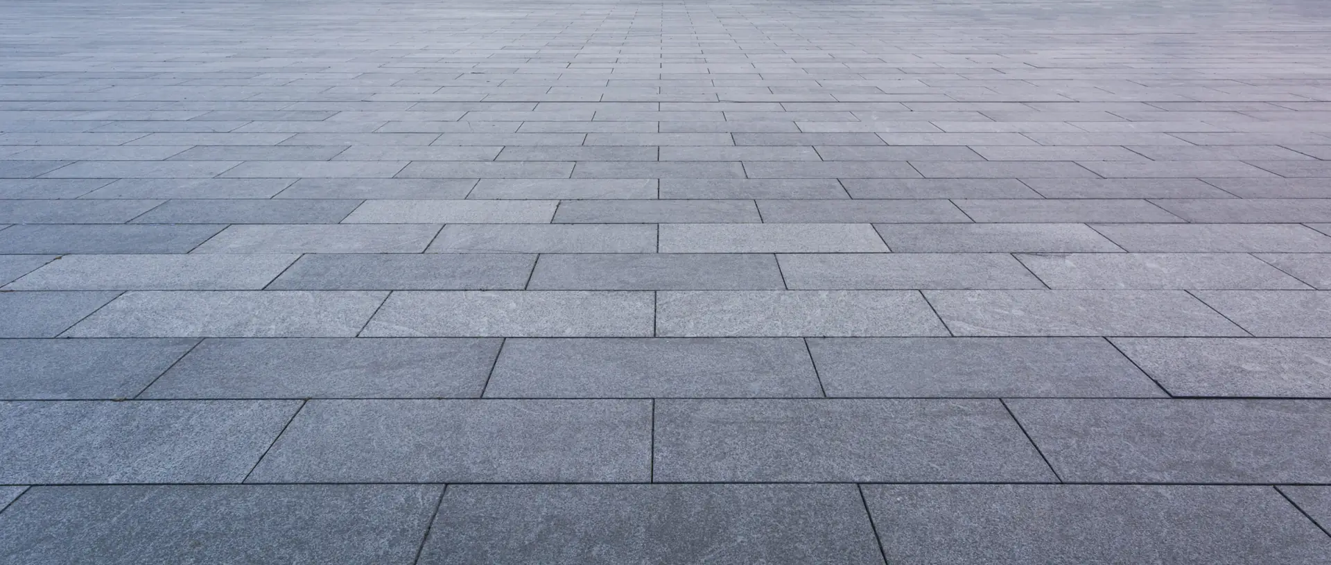 Close-up of grey block paving laid in a neat stretcher bond pattern