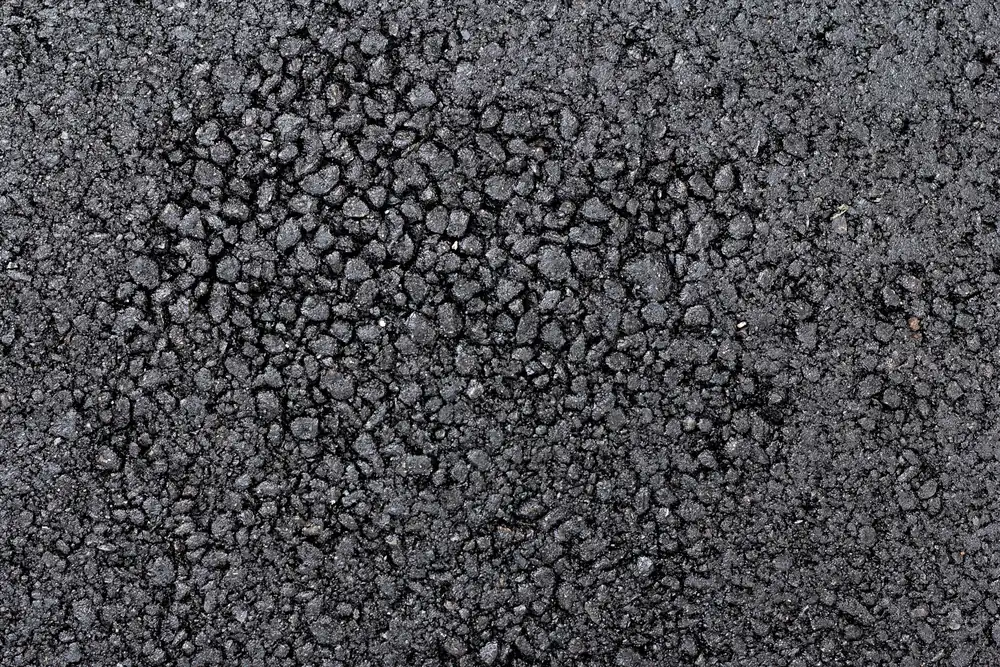 Close-up of a dark resin bound driveway surface showing the aggregate texture
